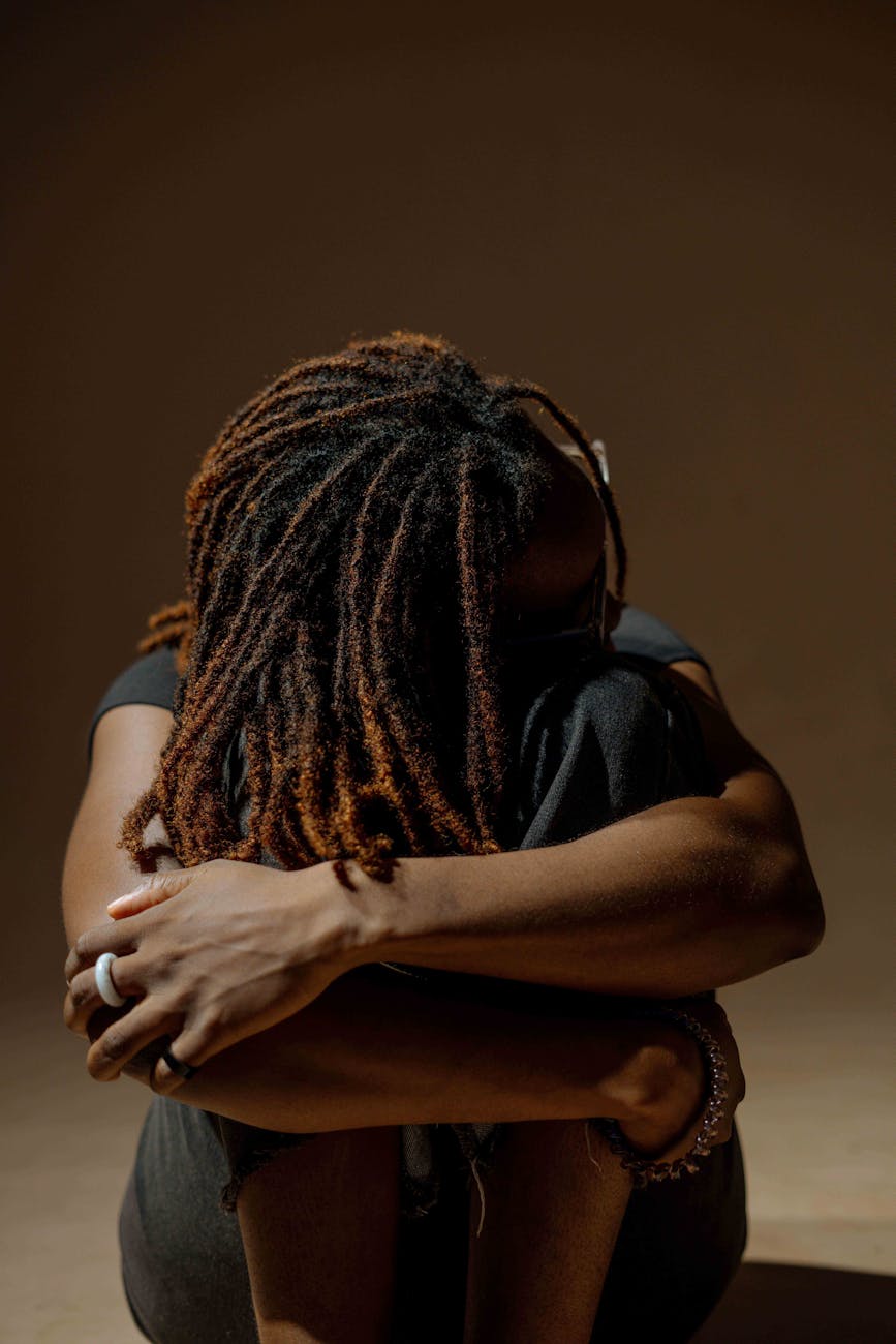 a woman with dreadlocks sitting on the ground